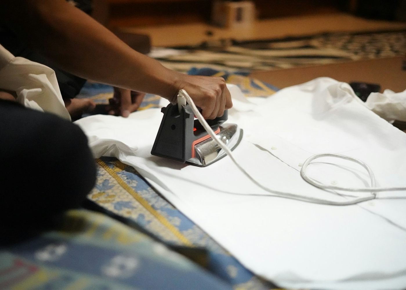 Hands pressing a crisp white shirt with a steam iron